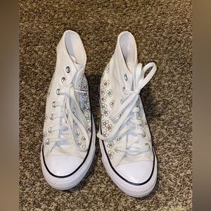 White Chuck Taylor converse for sale with flowers on the bottom.